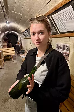 Historikerin Stephanie Kanne zeigt im Röhrenbunker eine geschmolzene Glasflasche. - © Wolfgang Stelljes/dpa-tmn