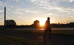 Ein Jogger in Düsseldorf: Auch Sport kann an extremen Hitzetagen gefährlich werden. - © Lukas Fortkord/dpa