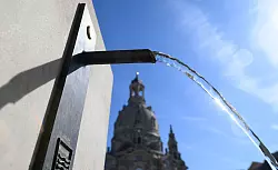 In Dresden spendet ein Trinkwasserbrunnen öffentlich zugängliche Abkühlung. - © Robert Michael/dpa