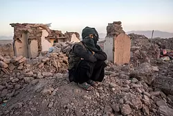 Ein Afghane sitzt in den Tr&uuml;mmern seines Hauses im Bezirk Zenda Jan in der Provinz Herat. - &copy; Ebrahim Noroozi/AP/dpa