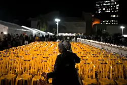 St&uuml;hle, auf denen Bilder mit menschlichen Augen angebracht sind: Mit der Kunstinstallation in Tel Aviv wird der Geiseln gedacht, die von der Hamas festgehalten werden. - &copy; Maya Alleruzzo/AP/dpa