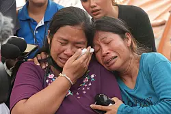 Menschen warten auf Nachrichten über Angehörige, die in den Trümmern des Hochhauses in Bangkok vermutet wurden. - © Sakchai Lalit/AP/dpa