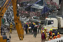 An den Trümmern eines Hochhauses in Bangkok laufen die Bergungs- und Rettungsarbeiten. - © Manish Swarup/AP/dpa