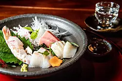 Sashimi ist roher Fisch ohne Beilagen, lediglich mit ein paar Würzzutaten serviert. Sojasoße, Wasabi und Kresse sind typische Aromen zur Verfeinerung - © Zacharie Scheurer/dpa-tmn