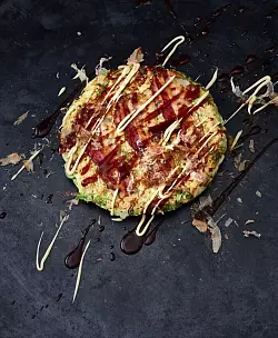 Okonomiyaki ist ein Wohlfühlgericht der japanischen Küche. Der herzhafte Pfannkuchen, der oft auch als «japanische Pizza» bezeichnet wird, besteht aus einem einfachen Teig auf der Basis von Mehl, Ei und Dashi-Brühe und wird mit fein geschnittenem Kohl verfeinert. - © Julia Hörsch/Gräfe und Unzer Verlag/dpa-tmn