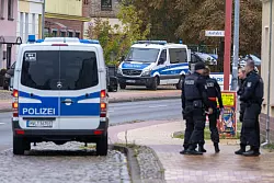 Die Beamten befragen Anwohner. - © Stefan Sauer/dpa