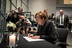 Altkanzlerin Angela Merkel schreibt ins Kondolenzbuch. - &copy; Michael Kappeler/dpa