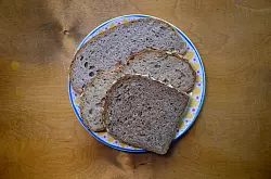 Scheiben von Mischbrot, Vollkornbrot und Kürbiskernbrot liegen auf einem Teller. (Symbolbild) - © Robert Michael/dpa