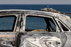 Ein verbranntes Fahrzeug auf der Insel Rhodos. - &copy; Christoph Reichwein/dpa