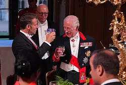 Emmanuel Macron (l) und König Charles III. stießen auf die britisch-französische Freundschaft an. - © Yui Mok/PA Wire/dpa