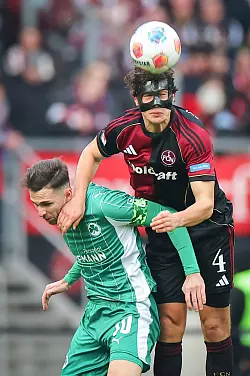 Nürnbergs Verteidiger Fabio Gruber (r) im Luftkampf mit Fürths Branimir Hrgota. - © Daniel Karmann/dpa