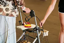 Eine junge Frau wirft Geld in ein Beh&auml;ltnis an einem Gehwagen einer &auml;lteren Dame, die in einer Unterf&uuml;hrung singt. (Archivbild) - &copy; Annette Riedl/dpa