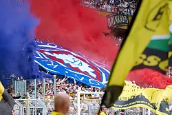 Fans von Holstein Kiel zündeten beim Abschied aus der Bundesliga ein Meer aus blau-roter Pyrotechnik. - © Bernd Thissen/dpa