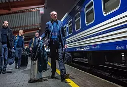 Merz ist mit dem Zug unterwegs - und stichelt gegen die Deutsche Bahn. - © Michael Kappeler/dpa