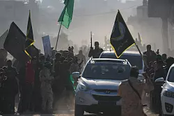 Menschenmenge begrüßt bewaffnete Mitglieder der Terrororganisationen Hamas und Islamischer Dschihad. - © Abdel Kareem Hana/AP/dpa