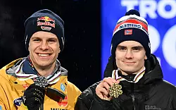 Andreas Wellinger (links) und Weltmeister Marius Lindvik mit ihren Medaillen nach dem WM-Springen. - © Hendrik Schmidt/dpa