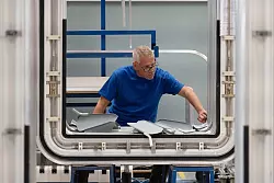 Ein Mitarbeiter der H&uuml;bner-Werke arbeitet an einem &Uuml;bergangssystem der ICE 3-Flotte. - &copy; Swen Pf&ouml;rtner/dpa