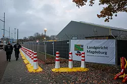Polizisten laufen vor dem tempor&auml;ren Gerichtsgeb&auml;ude des Landgerichtes Magdeburg Streife. - &copy; Jan Woitas/dpa