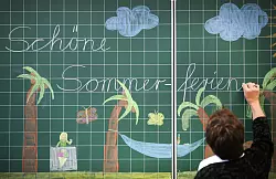 Eine Lehrerin schreibt &laquo;Sch&ouml;ne Sommerferien&raquo; an die Tafel einer Grundschulklasse. (Archivfoto) - &copy; Ina Fassbender/dpa