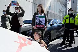 Demonstrierende veranstalten eine Kundgebung zur Unterstützung der iranischen Bergsteigerin Rekabi vor der iranischen Botschaft in Seoul. - © Ahn Young-Joon/AP/dpa