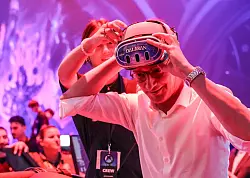 NRW-Ministerpr&auml;sident Hendrik W&uuml;st (CDU) sitzt bei der Gamescom auf einem Hightech-Stuhl und testet das Spiel &laquo;Flucht aus Dalaran&raquo;. (Archivbild) - &copy; Oliver Berg/dpa