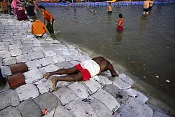 Ein Teilnehmer des Pilgerfests Maha Kumbh Mela spricht ein Gebet, bevor er ein Bad im Fluss nimmt. - © Prabhat Kumar Verma/ZUMA Press Wire/dpa