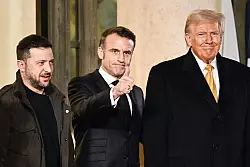 Ziehen in Sachen Ukraine-Politik nicht an einem Strang: der ukrainische Präsident Selenskyj (l.), Frankreichs Staatschef Macron und US-Präsident Trump. (Archivbild) - © Julien De Rosa/AFP/dpa