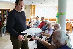 Tiertrainer Andr&eacute; Weseloh (l), der mit seinen Sch&uuml;tzlingen regelm&auml;&szlig;ig Senioreneinrichtungen besucht, hat auch Wei&szlig;hauben-Kakadu Sammy nach Barsb&uuml;ttel mitgebracht. - &copy; Ulrich Perrey/dpa