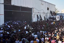 Palästinenser tragen Säcke mit Mehl, nachdem sie ein Lagerhaus des Welternährungsprogramms der Vereinten Nationen in Zawaida im zentralen Gazastreifen gestürmt haben. - © Abdel Kareem Hana/AP/dpa