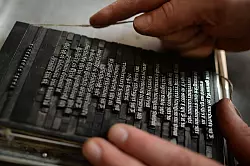 Ein Schriftsetzer des Museums f&uuml;r Druckkunst Leipzig bindet in Leipzig Bleilettern mit einer Kolumnenschnur ein. - &copy; Hendrik Schmidt/dpa-Zentralbild/dpa