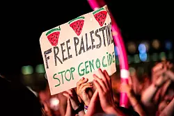 &laquo;Free Palestine - Stop Genocide&raquo; steht auf einem Plakat bei dem Auftritt vom US-Rapper Macklemore. Es war eine von wenigen politischen Botschaften im Publikum. - &copy; Sina Schuldt/dpa