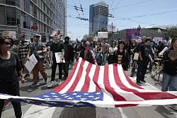 Demonstranten in San Francisco marschierten mit einer großen US-Flagge. - © Yalonda M. James/San Francisco Chronicle/AP/dpa