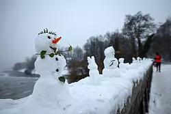 Eine ungew&ouml;hnliche Ausstellung: Zahlreiche kleine und winzige Schneefiguren stehen auf einer Mauer der Krugkoppelbr&uuml;cke an der Alster im Hamburg. - &copy; Christian Charisius/dpa