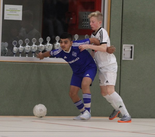 Schirmt das Leder gekonnt vor dem Gegenspieler ab: Der Bad Salzufler Jonas Mike Derbas (blaues Trikot) bei der Partie gegen den SC Verl. Im Hintergrund sind die ganzen Pokale aufgereiht. - © Sebastian Lucas
