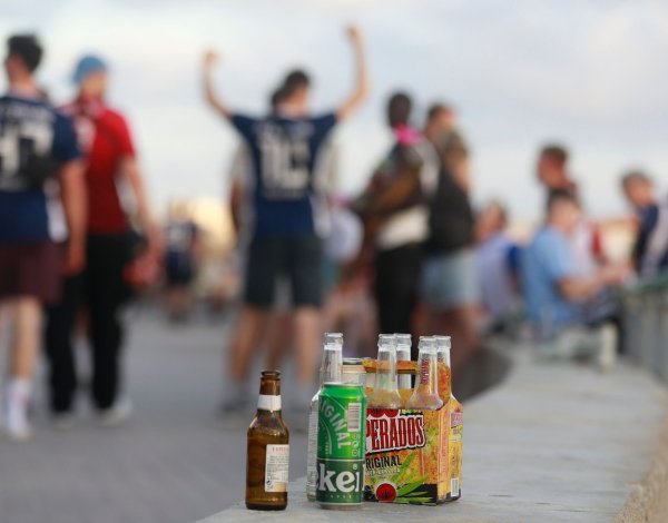 Menschen haben sich am Abend an der Promenade am Strand von Arenal versammelt und trinken Alkohol. - © Clara Margais/dpa