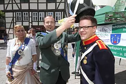 Wichtiges Accessoire: König Sascha Ruge setzt Jan Niklas Witt den noch fehlenden Hut zu seiner Uniform als Lippischer Schütze auf. Jetzt kann das Schützenfest in Bad Salzuflen starten. - © Daniel Hobein