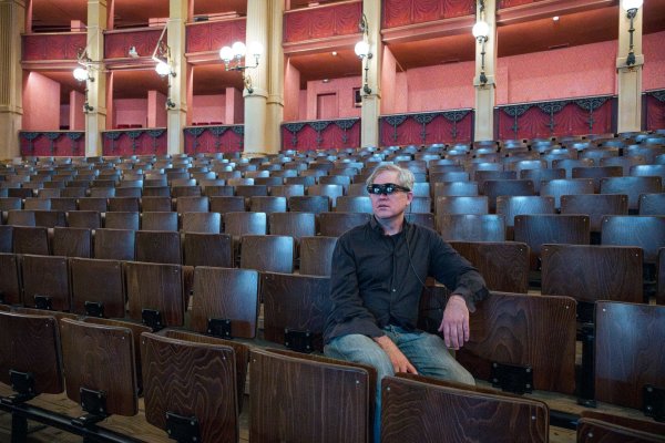 Jay Scheib, Regisseur der Neuproduktion des «Parsifal», sitzt mit einer Augmented Reality (AR) Brille im Zuschauerraum des Festspielhauses. - © Daniel Vogl/dpa