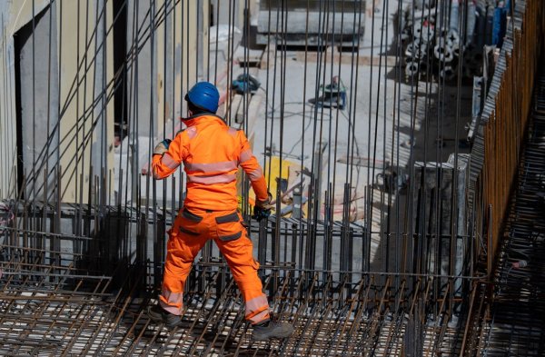 Ein Bauarbeiter verlegt auf einer Baustelle Stahlmatten. - © Sven Hoppe/dpa