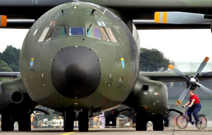 Ein Bauarbeiter fährt auf einem Fahrrad zwischen den parkenden Transall-Maschinen auf dem Fliegerhorst Wunstorf hindurch. Auf der Basis entstehen derzeit neue Wartungshallen für den Transall-Nachfolger Airbus A-400, der ab 2014 auf der Basis erwartet wird. - © Foto: Tyler Larkin