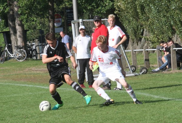 Lipperreihes Trainer Carsten Schulze (im Hintergrund mit roten Schuhen) und sein Betreuer Tim Meister (rotes Trikot) schauen dem Zweikampf zwischen Aspes Jan-Hendrik Lange (links) und Ruben Leon Steinkamp zu. - © Dietmar Welle