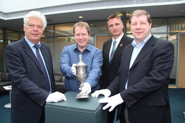 Empfindliches Schmuckstück: Nur mit Handschuhen darf der Silberpokal angefasst haben, den Bürgermeister Dr. Wolfgang Honsdorf, Stadtarchivar Arno Beuke, Sparkassen-Regionalleiter Marko König und Dr. Stefan Wiesekopsieker vom Heimat- und Verschönerungsverein hier in der Schalterhalle der Sparkasse Schötmar präsentieren. - © Dieter Asbrock