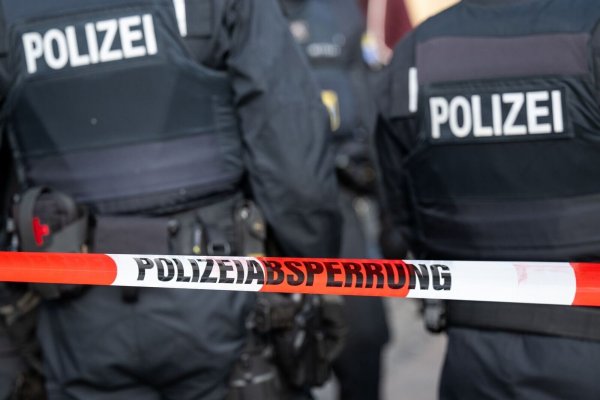 Polizisten stehen hinter einem Polizei-Flatterband. - © Hannes P. Albert/dpa