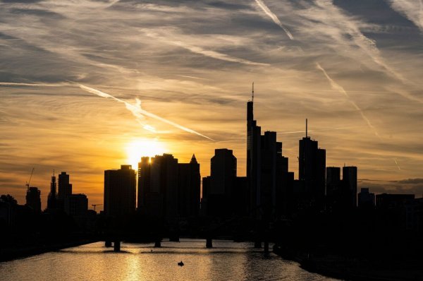 Bankentürme der Frankfurter Skyline vor einem sonnengefärbten Himmel. - © Boris Roessler/dpa
