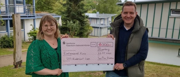 Tobias Nordmeyer übergibt den symbolischen Scheck an Laura Hesse vom SOS-Kinderdorf Lippe. - © SynFlex Elektro GmbH