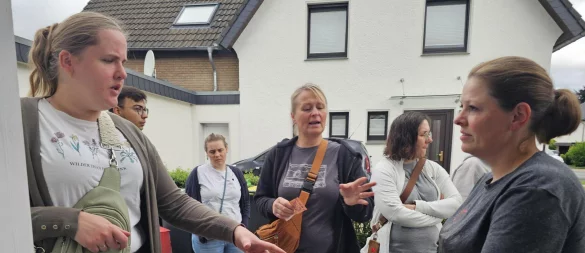 Daniela Tesch (links) erklärt, wie man den Hennen den Body überziehen kann. Damit soll sichergestellt werden, dass der Hahn die zum Teil nackten Hennen nicht mit seinem Sporn verletzen kann. - © Astrid Sewing
