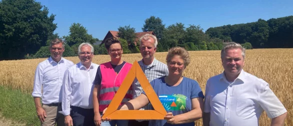 Hier könnte die Trasse langführen: Vlothos Bürgermeister Rocco Wilken, Landrat Jürgen Müller, Sarah Brodowski von den Landfrauen im Kreis Herford, Hermann Dedert, Voritzender des Landwirtschaftlichen Kreisverbandes Herford-Bielefeld, Stefanie Rothenstein, zweite Vorsitzende von Widuland sowie Herfords Bürgermeister Tim Kähler stehen vor einem Feld des Hofs Bohnenkamp. Dahinter liegt der Wald, den die Trasse durchschneiden könnte. - © Jobst Lüdeking