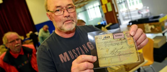 Hartmut Sohn, Vorsitzender des Briefmarkensammler-Vereins Lippe, hält eine Postanweisung per Nachnahme über 21 Mark von 25.05.1904 in der Hand. - © Nicole Ellerbrake