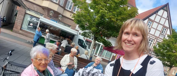 Künstlerin Friederike Hoppe alias Rike Hoppse bietet den Menschen auf dem Blomberger Marktplatz eine Spielkarte an. Die Spielanweisungen darauf bestehen aus kleinen Herausforderungen im Alltag, so etwa "Du fragst die Person, die du vom Sehen kennst, nach ihrem Namen" und "Du machst deinem Gegenüber ein unerwartetes Kompliment". - © Michaela Weiße