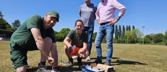 Die Mitarbeiter des Bauhofs, Marian Kinski (links) und Vanessa Lükemann, markieren die Begrenzungslinie für das American-Football-Spielfeld. Bauhofleiter Leif Salitter und Beigeordneter Thorsten Paulussen (rechts) freuen sich, dass das Stadion am Werreanger künftig noch mehr genutzt wird. Die White Hawks laden hier zu ihren Heimspielen ein. - © Astrid Sewing