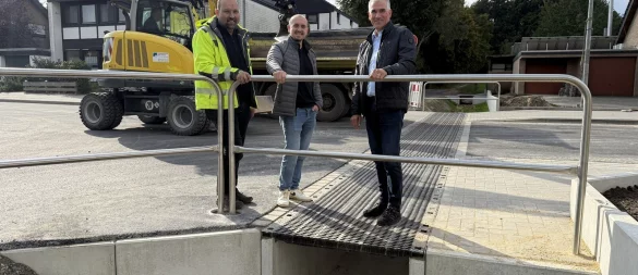 Sven Anders (von links) und Sven Ranft vom Fachteam Stadtentwässerung und Wasserwirtschaft sowie Erster Beigeordneter Thorsten Paulussen freuen sich über die Fertigstellung der Maßnahmen zum Hochwasser- und Überflutungsschutz im Lönsweg. - © Stadt Lage